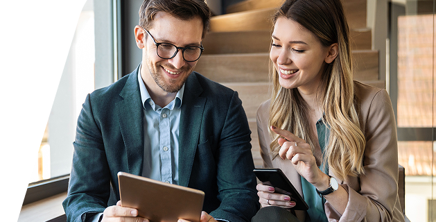 Profissional sorrindo usando tablet em ambiente de trabalho